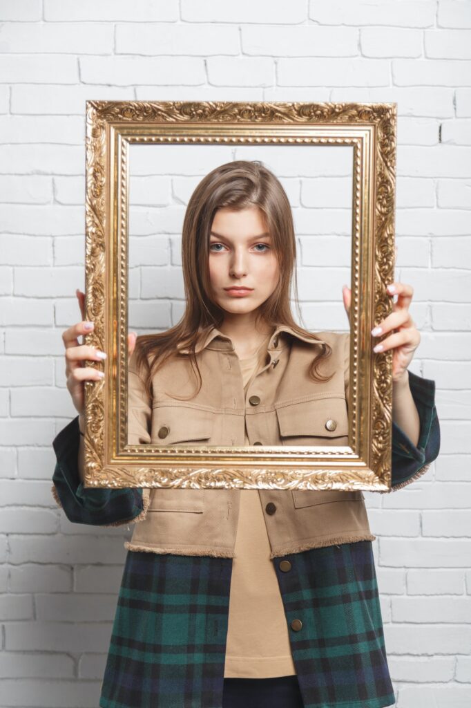 young woman holds the frame in front of her boundary and stereotype concept
