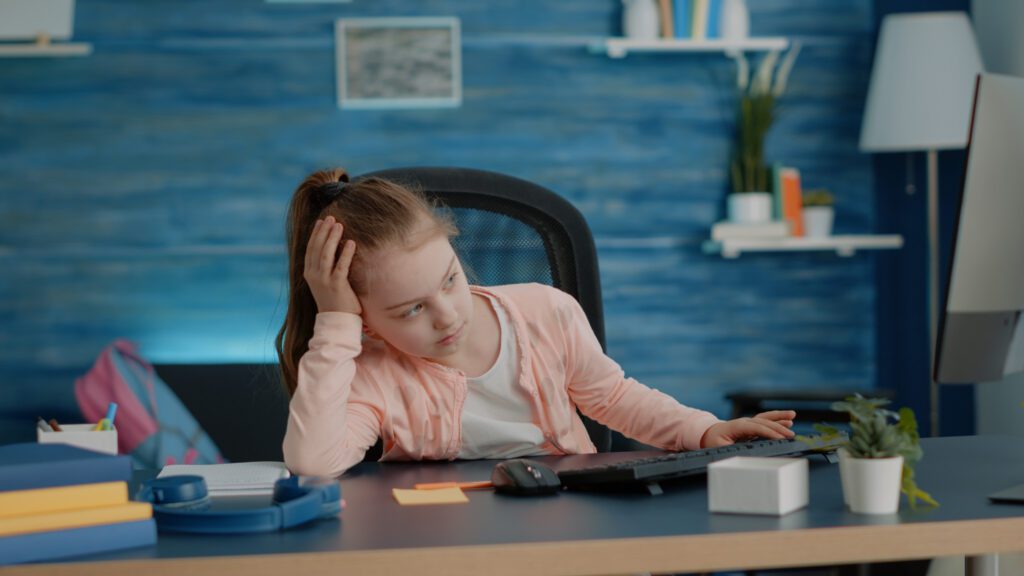 Exhausted child looking at computer for online classes