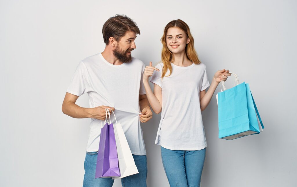 Cheerful young couple t-shirt jeans emotions joy shopping in the store